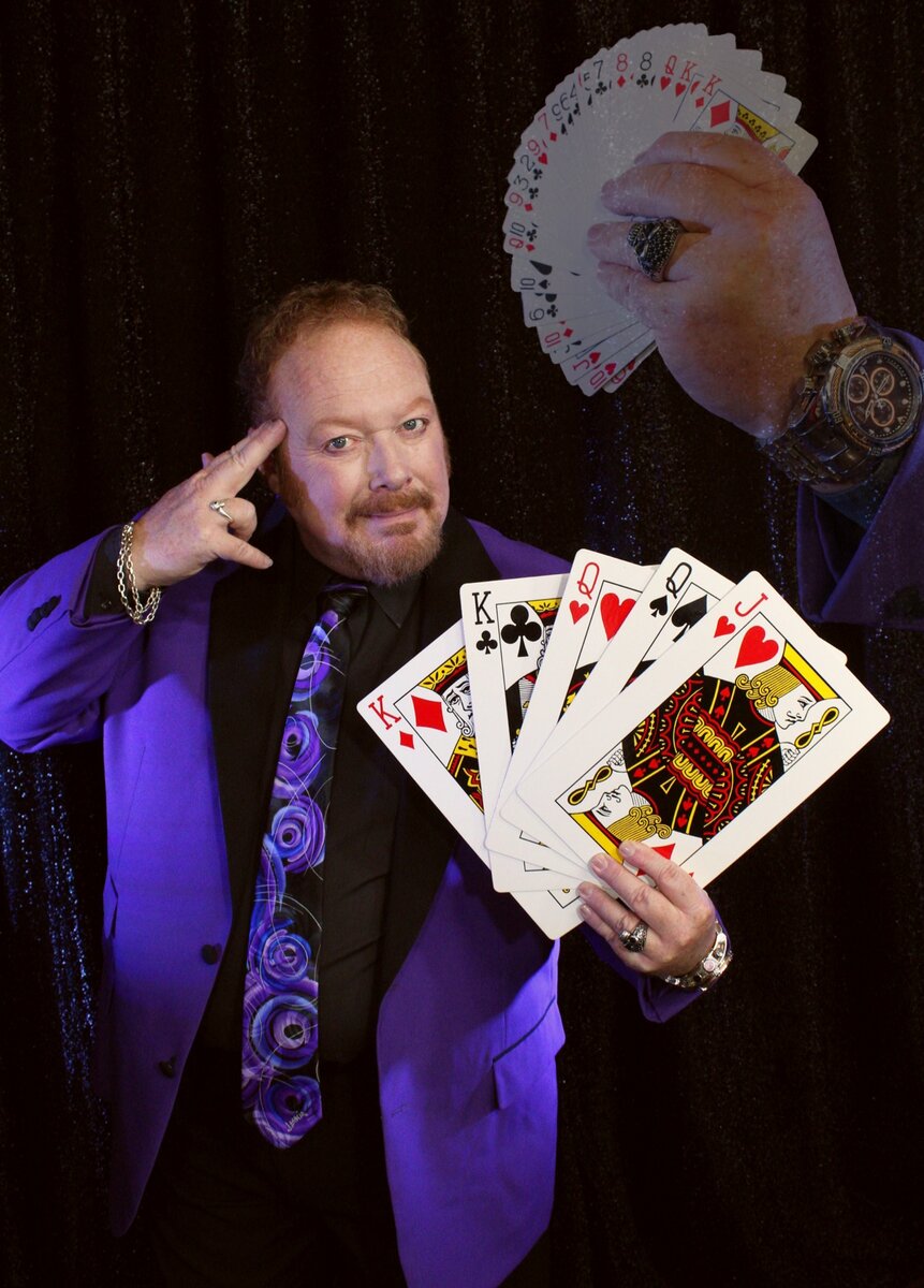chicago-trade-show-magician-john-measner-headshot Chicago trade show magician John Measner holding a fanned deck of playing cards in a promotional portrait